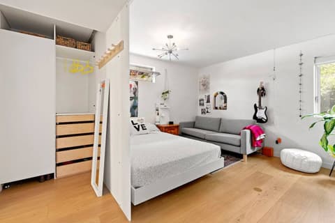 The third bedroom, designed with a teenager or young adult in mind, offers a welcoming space with a cozy sitting area and a convenient walk-in closet.