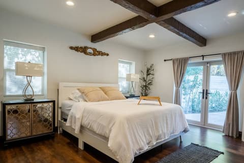 Generous bedroom drenched in natural light, featuring a cozy double bed, breathtaking outdoor vistas, and a full range of amenities for an utterly rejuvenating experience.