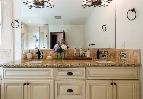 An efficient and well-lit bathroom, with a generously sized shower thoughtfully crafted to maximize guest comfort.