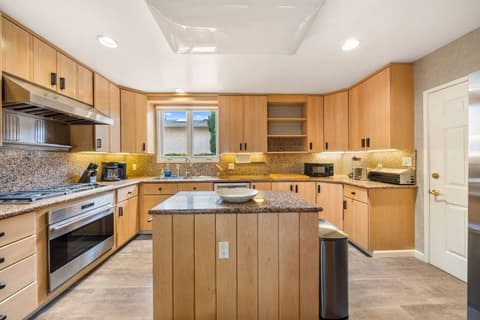 Modern kitchen w/ granite countertops, stainless steel appliances, and ample cabinet space. Includes an island for prep or dining and a cozy breakfast nook with stylish seating. Bright and inviting, this space truly feels like a home away from home.