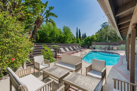 Gorgeous backyard oasis featuring a private pool, outdoor grill, and a cozy relaxation space, perfect for hosting family and friends during your Airbnb stay.