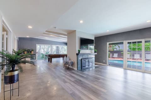Expansive and inviting living space, ideal for entertainment with a billiards table or enjoying the warmth of the fireplace.