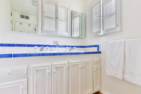Experience the luxury of a generously-sized bathroom featuring two sinks, a generously-sized shower, and abundant natural light.