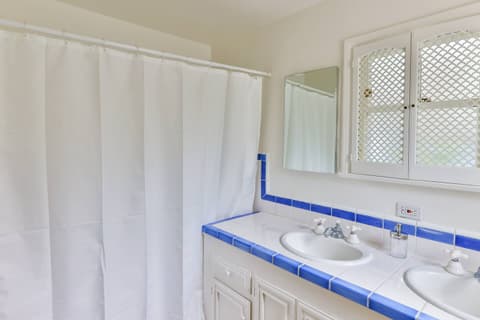 Experience the luxury of a generously-sized bathroom featuring two sinks, a generously-sized shower, and abundant natural light. Discover a haven of comfort and sophistication during your stay.