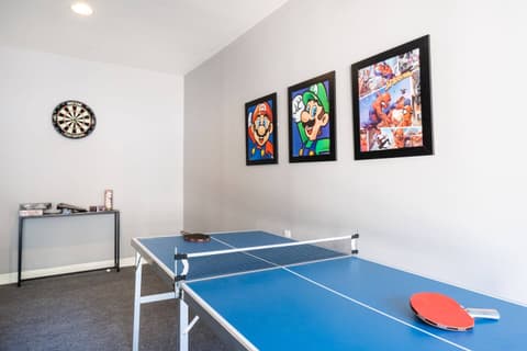 Expansive recreational space equipped with a ping pong table and an assortment of entertaining games.