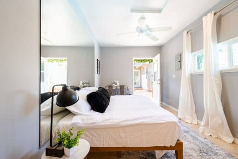 Generous bedroom drenched in natural light, featuring a cozy double bed, breathtaking outdoor vistas, and a full range of amenities for an utterly rejuvenating experience.